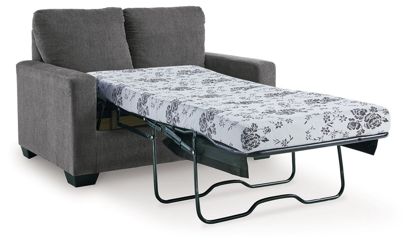 Dark gray sofa with pull-out bed frame and floral patterned mattress cover