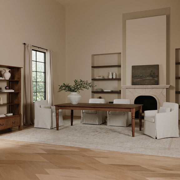 Beige slipcovered dining chair with wide arms and upholstered seat