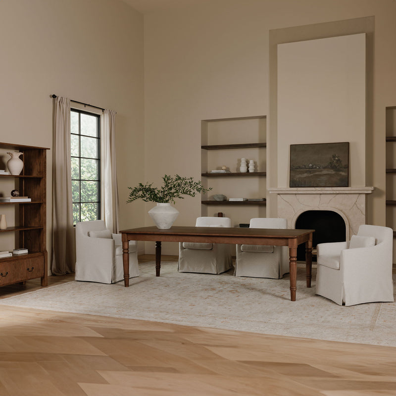 Beige slipcovered dining chair with wide arms and upholstered seat