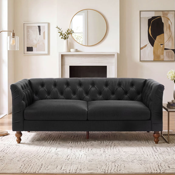 Black chesterfield-style sofa with tufted back, flared arms, and wooden legs