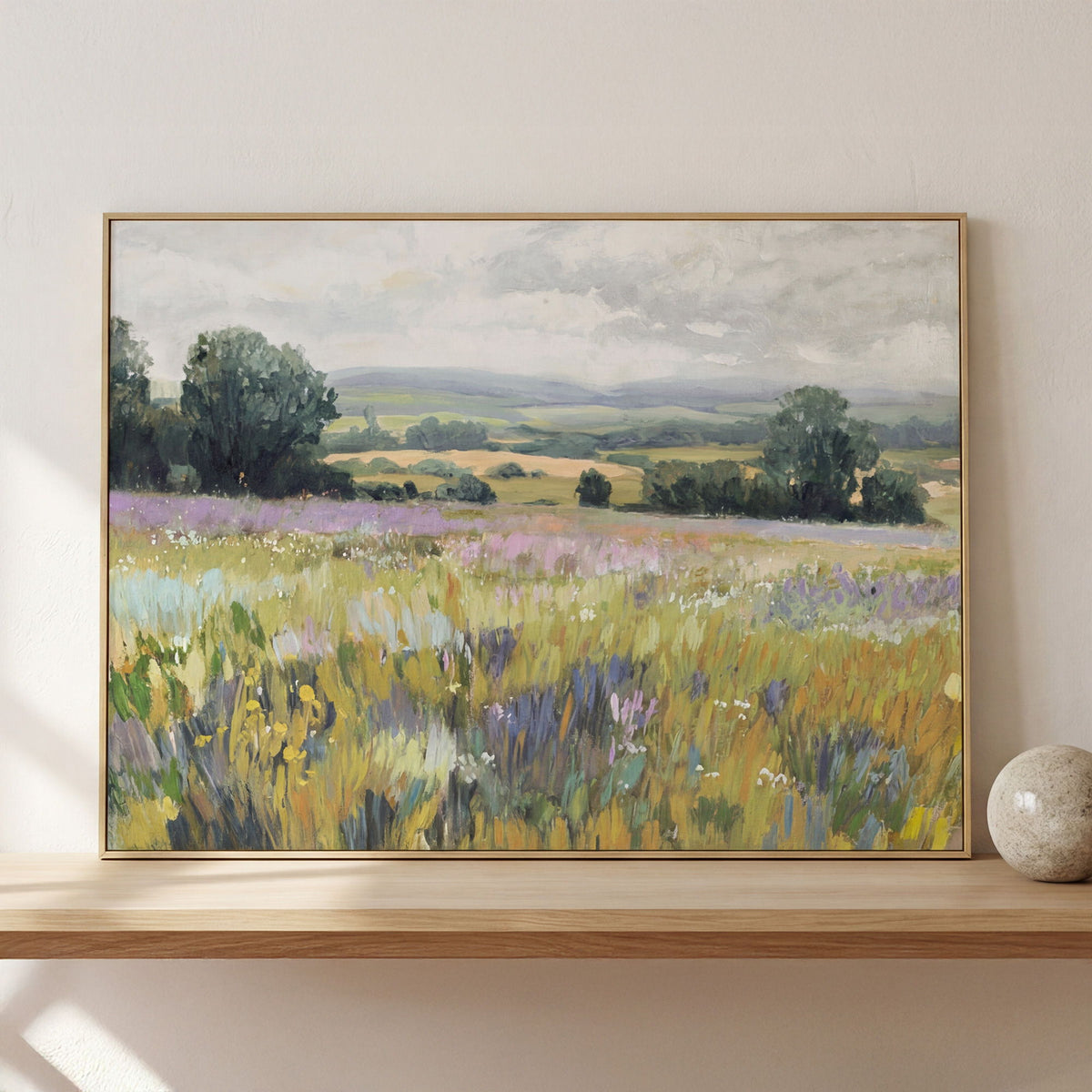 Framed landscape painting with purple and yellow wildflowers, trees, and distant hills