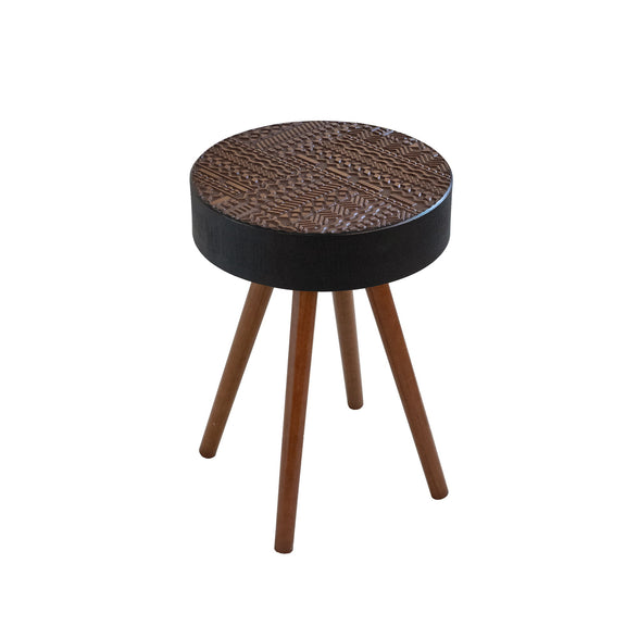 Round coffee table with carved dark top, dark pedestal base, and three brown tapered legs