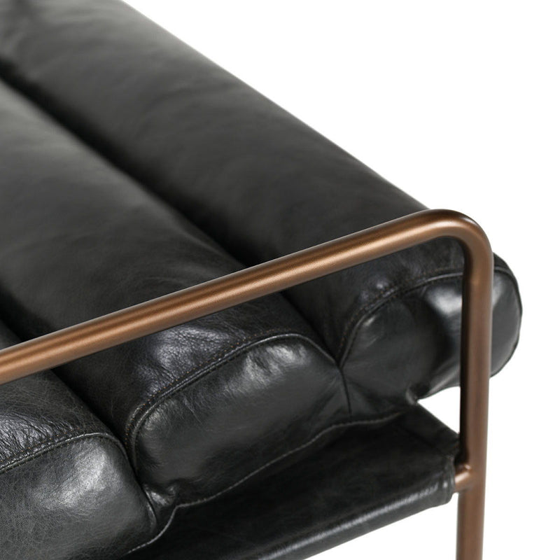 Jet black faux leather accent chair with bronze metal armrest and padded cushions