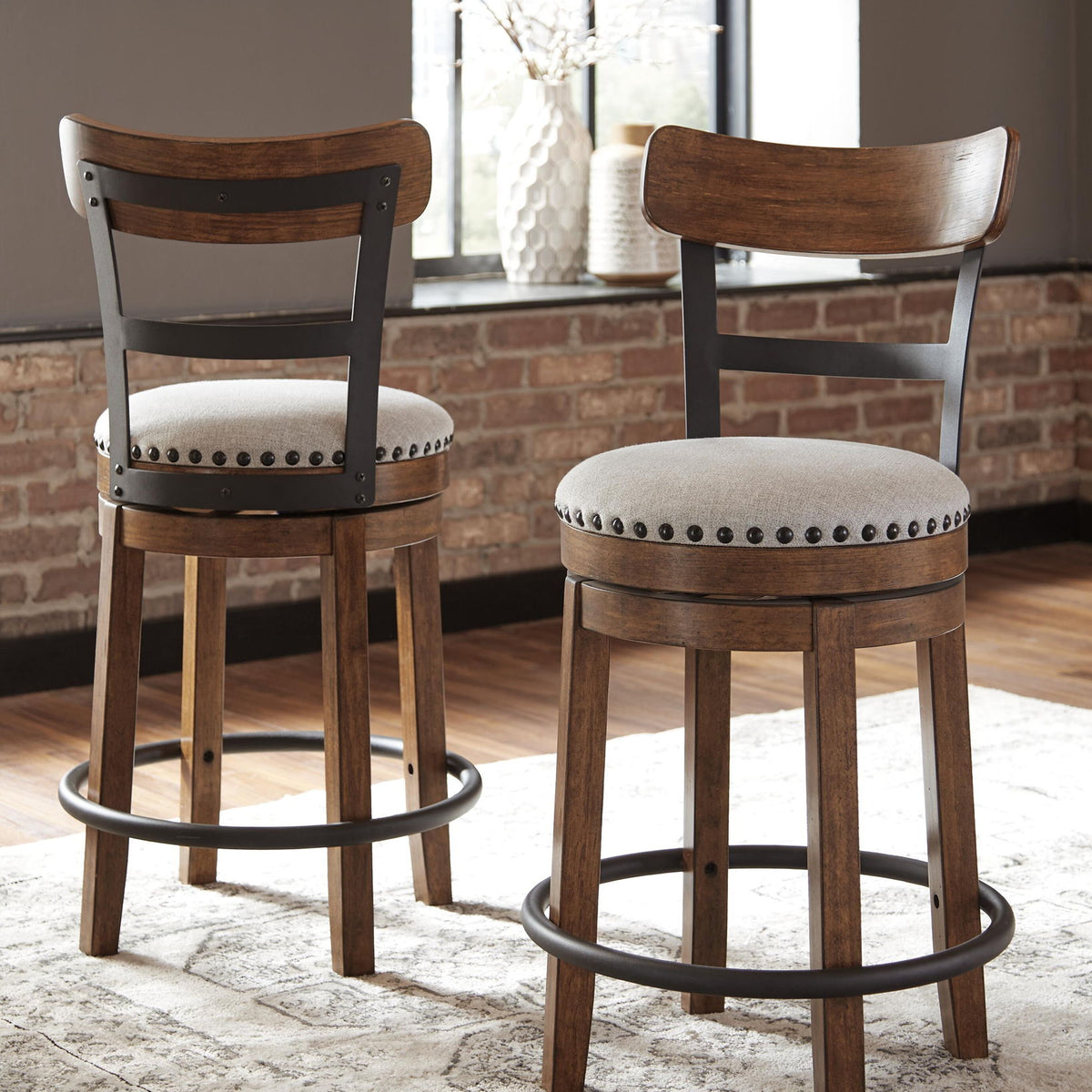 Two dark brown swivel bar stools with full backs, studded upholstered seats, and base rings