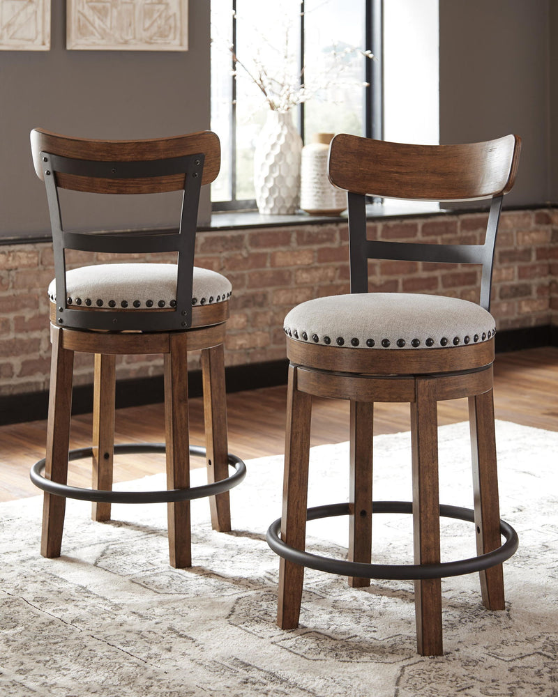 Two dark brown swivel bar stools with full backs, studded upholstered seats, and base rings