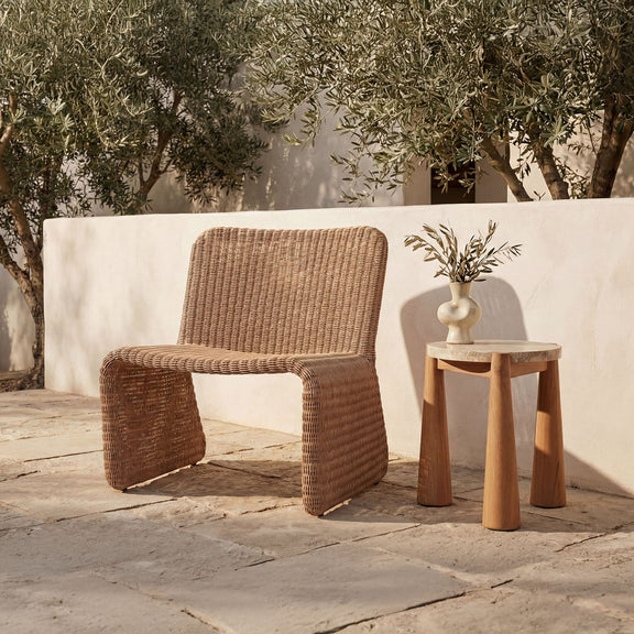 Natural woven outdoor accent chair with curved armrests and open-weave back