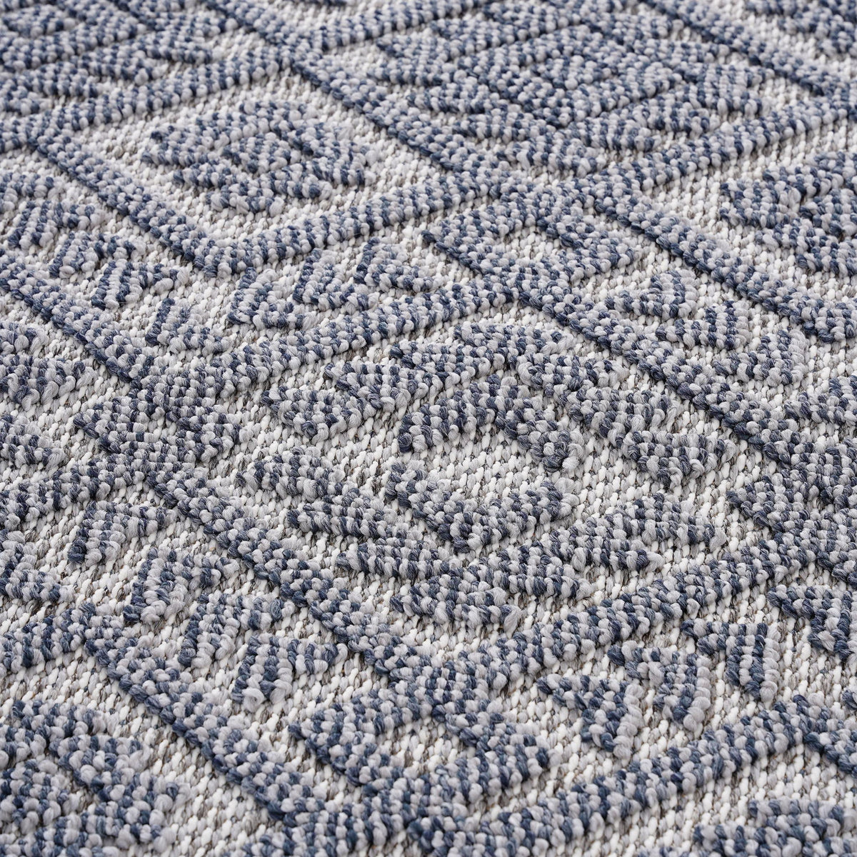 Blue-gray textured area rug with raised geometric pattern and looped pile