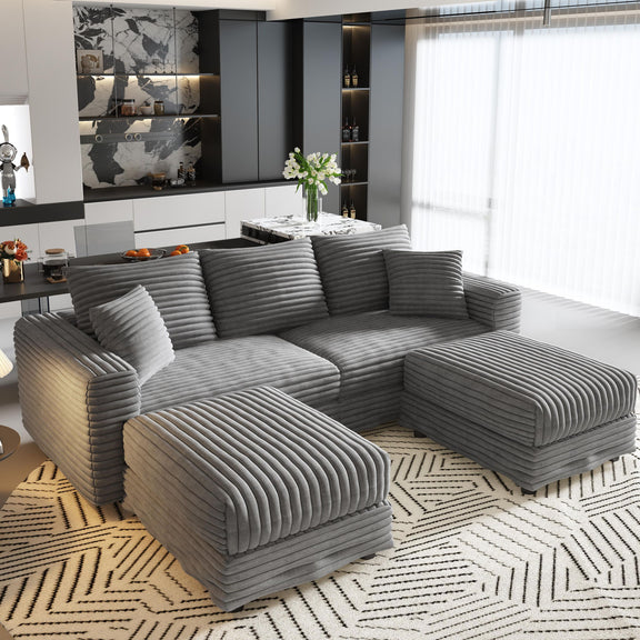 Dark gray sectional sofa with soft back pillows and two upholstered ottomans