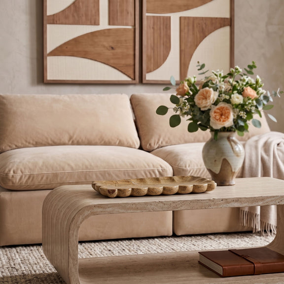Beige marble tray with scalloped edge on a coffee table