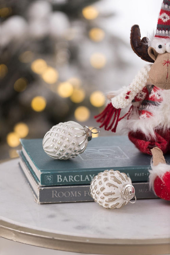 White glass hanging ball ornament with metal loop, shown with another ornament