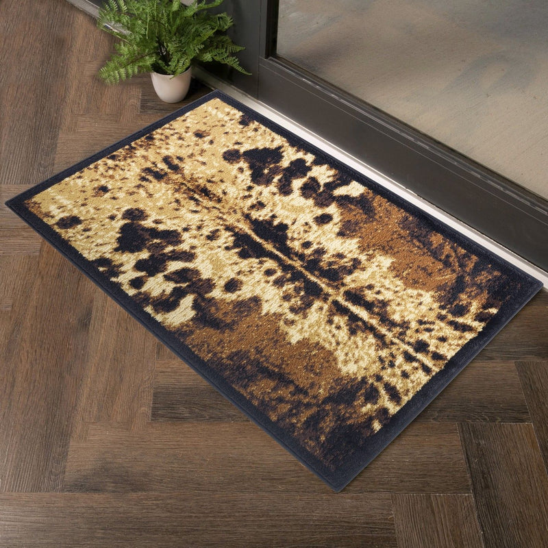 Southwest area rug with black border and scattered leopard spots in tan and dark brown.