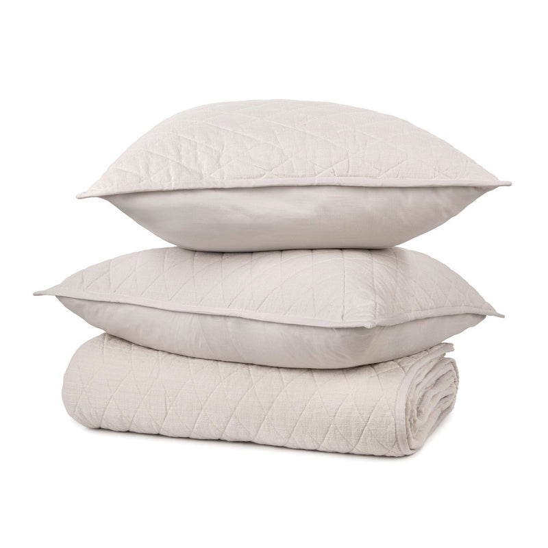 Ivory quilt with two matching pillows, stacked