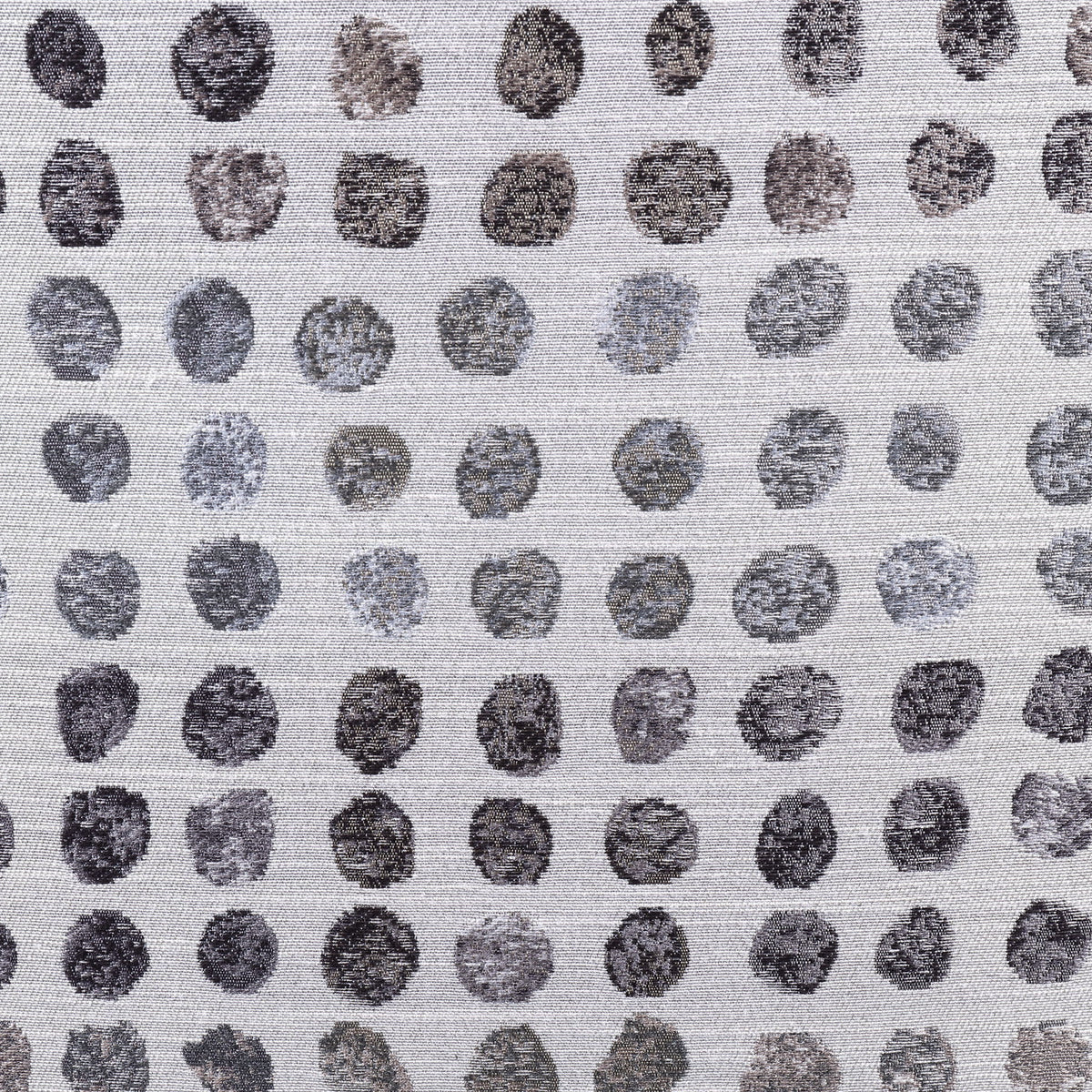 Close-up of ink-dot fabric upholstery on an ottoman, small dark circle pattern