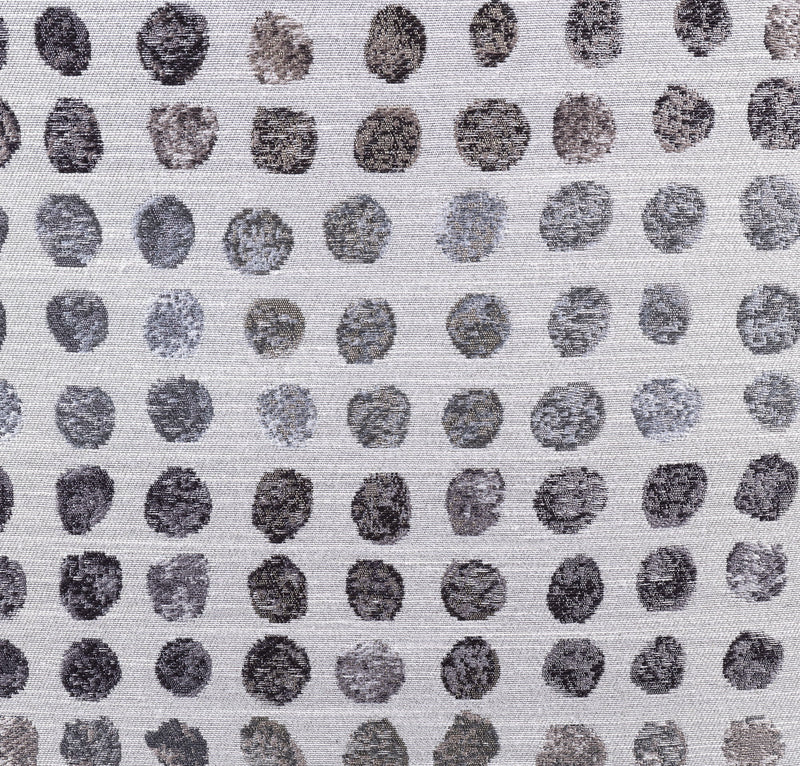 Close-up of ink-dot fabric upholstery on an ottoman, small dark circle pattern