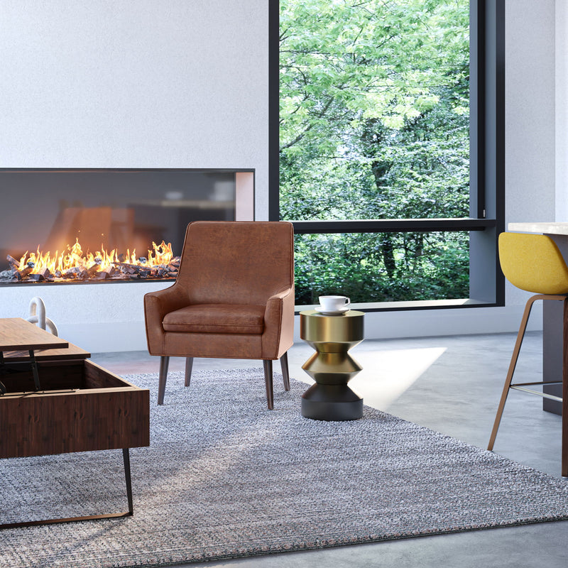 Round side table with brass-tone top and black hourglass pedestal in living room