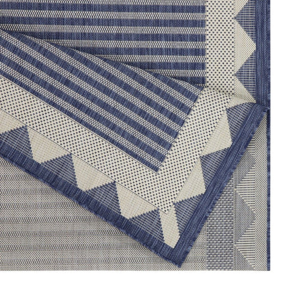 Blue striped area rug detail with triangular pattern border and zigzag edging