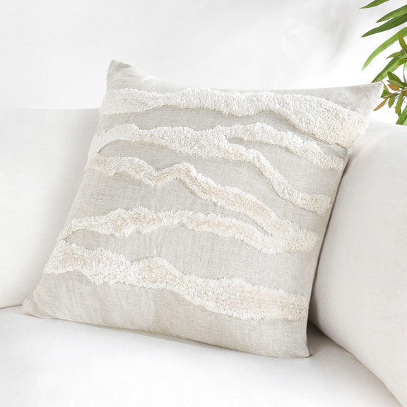 Light gray decorative pillow with raised white wavy stripe embroidery, angled view