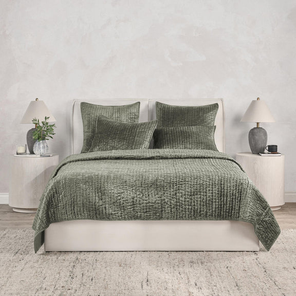 Green velvet quilt set with textured duvet and matching pillow shams on bed.