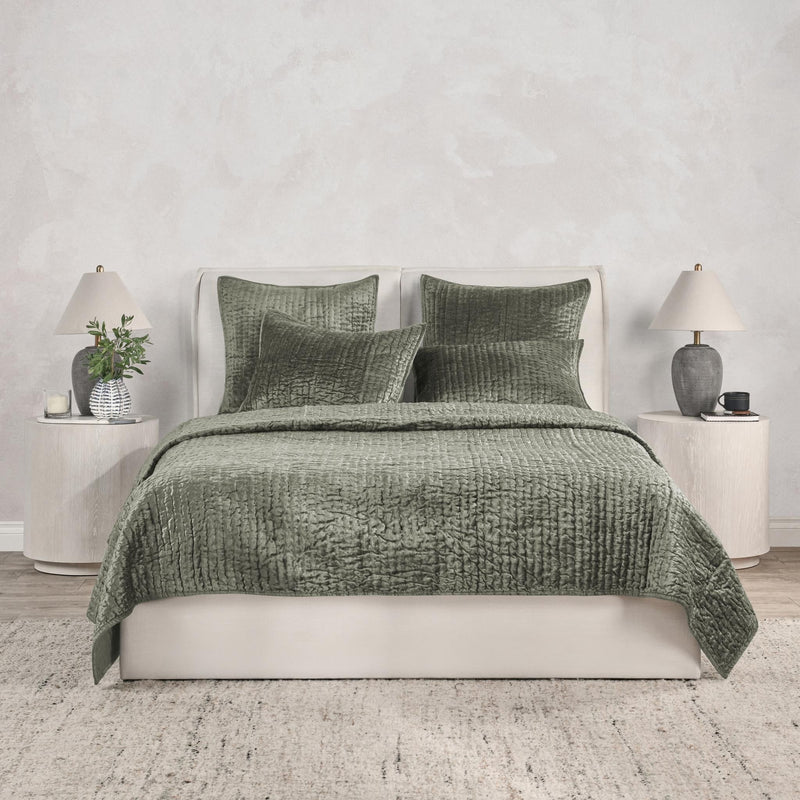 Green velvet quilt set with textured duvet and matching pillow shams on bed.