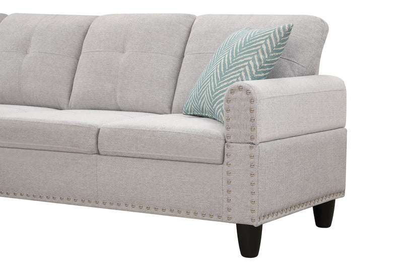 Light gray sofa arm with nailhead trim and blue patterned throw pillow