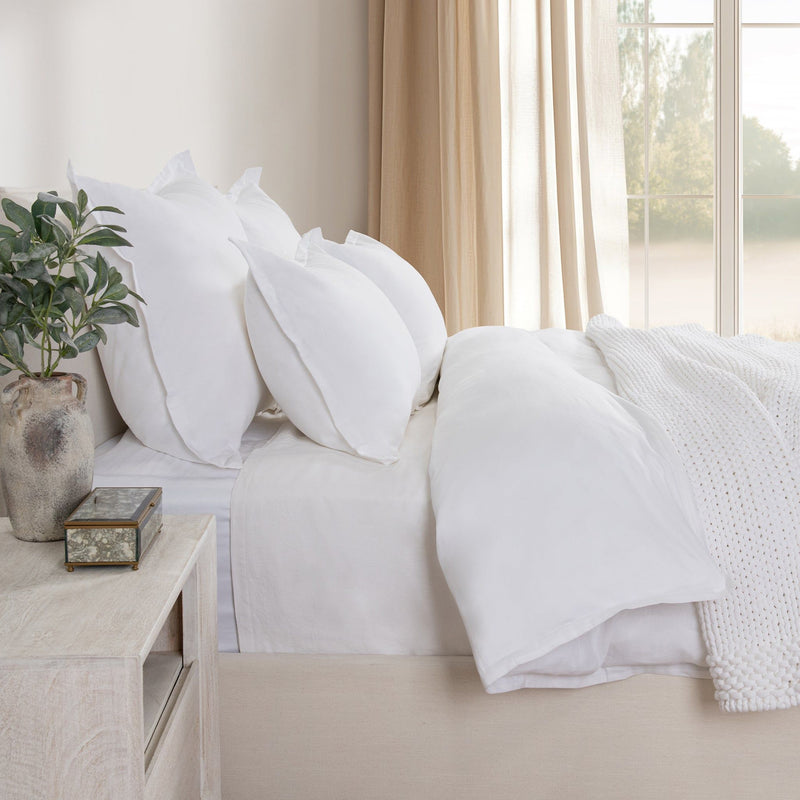 White decorative pillow shams on bed, smooth fabric with tailored seams