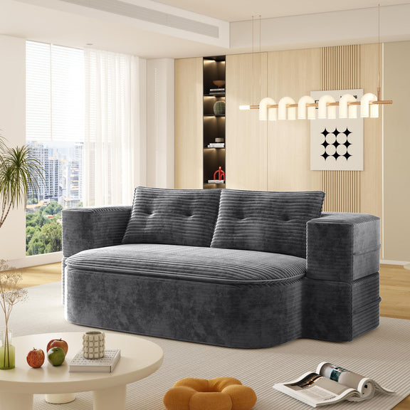 Dark gray convertible floor sofa bed with plush ribbed cushions and folded blanket