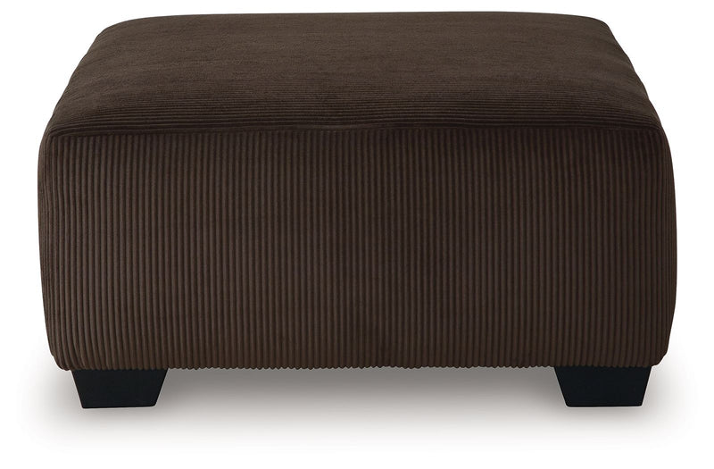 Dark brown ottoman with vertical ribbed fabric upholstery and low square legs