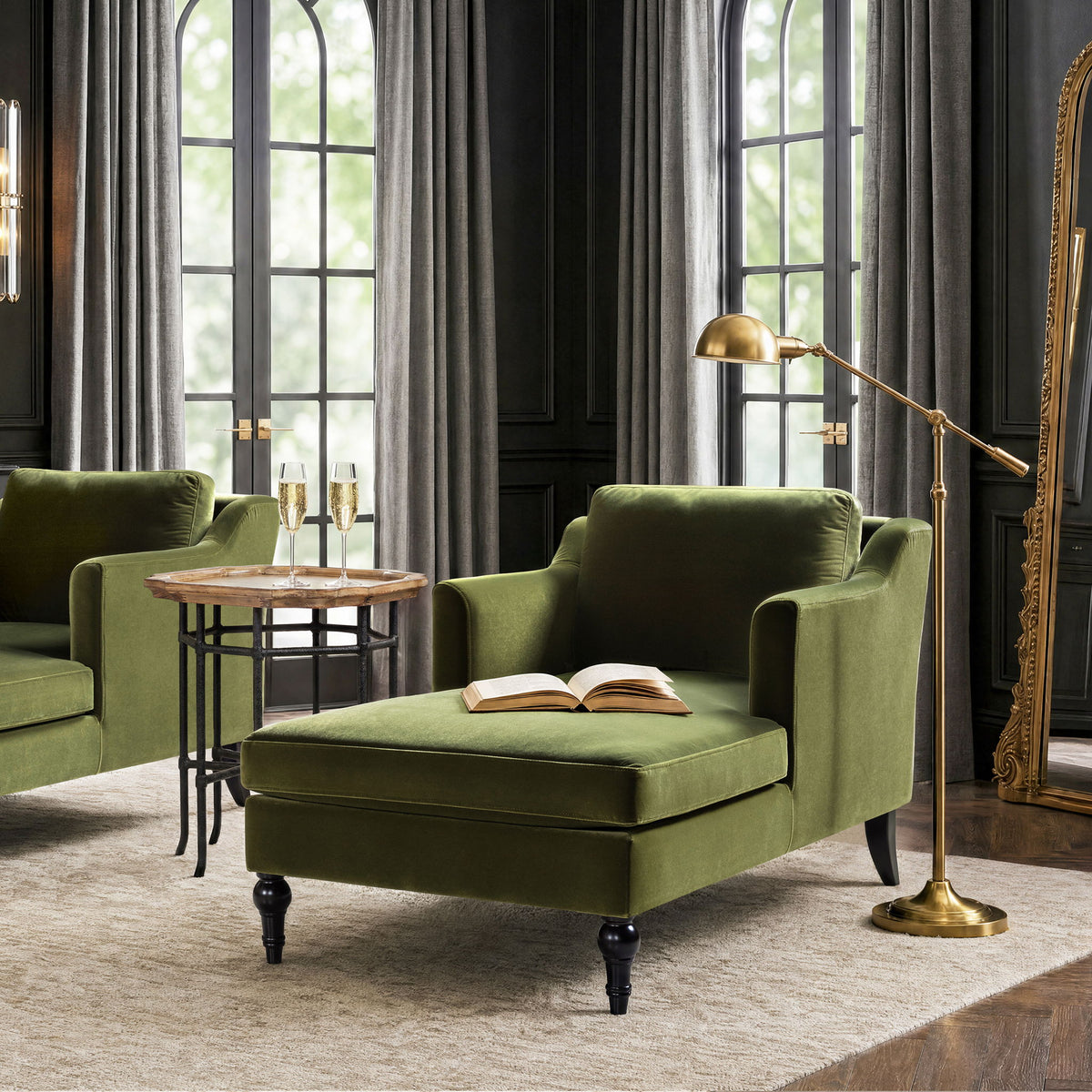 Green upholstered chaise lounge with curved arms, plush seat, and turned feet