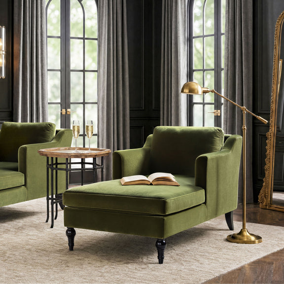 Green upholstered chaise lounge with curved arms, plush seat, and turned feet
