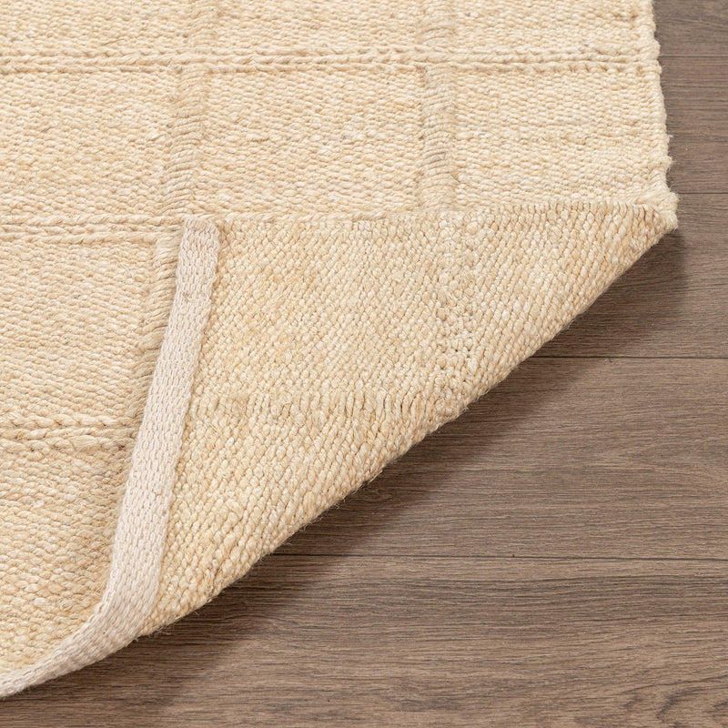 Natural jute area rug close-up of corner with woven edge and tight texture