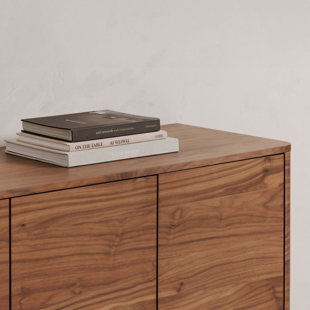 Walnut sideboard top with two cabinet doors and visible wood-grain surface; books