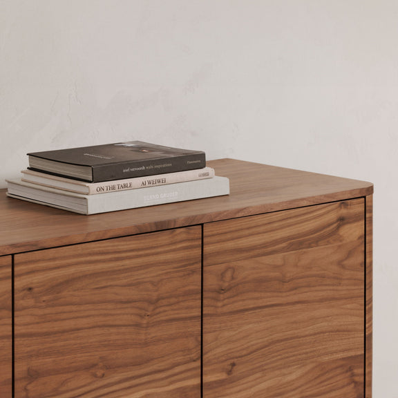 Walnut sideboard top with two cabinet doors and visible wood-grain surface; books