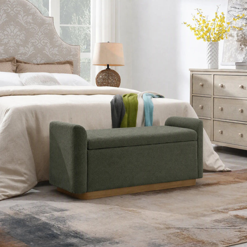 Dark green upholstered storage bench with corner legs and hinged top.