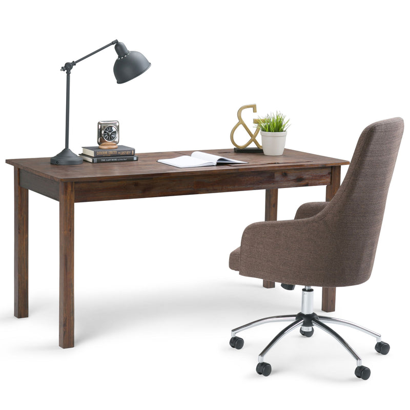 Charcoal-brown wood desk with lamp, papers, and gray swivel chair