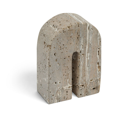 Beige travertine bookend with arched cutout, speckled stone texture