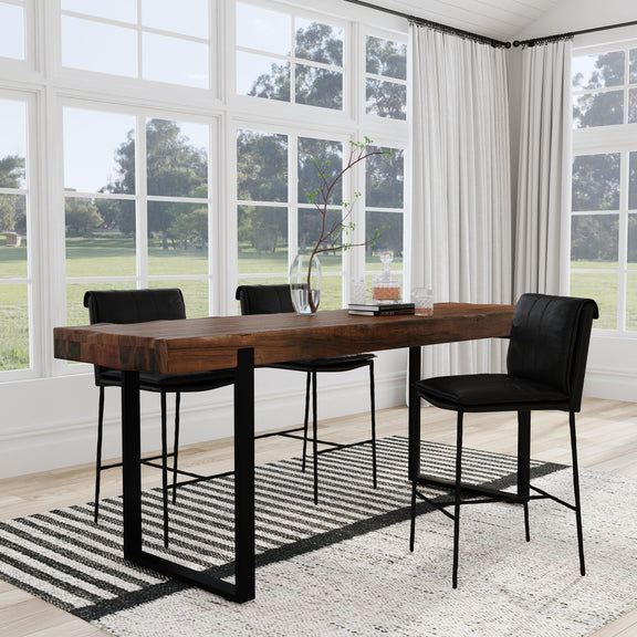 Reclaimed wood dining counter table with black metal legs in a room