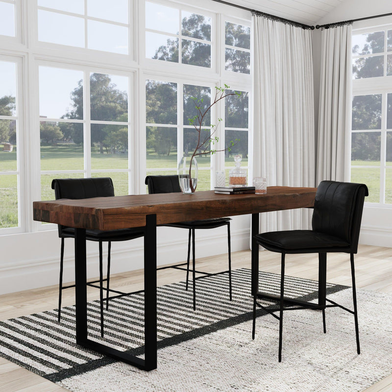 Reclaimed wood dining counter table with black metal legs in a room