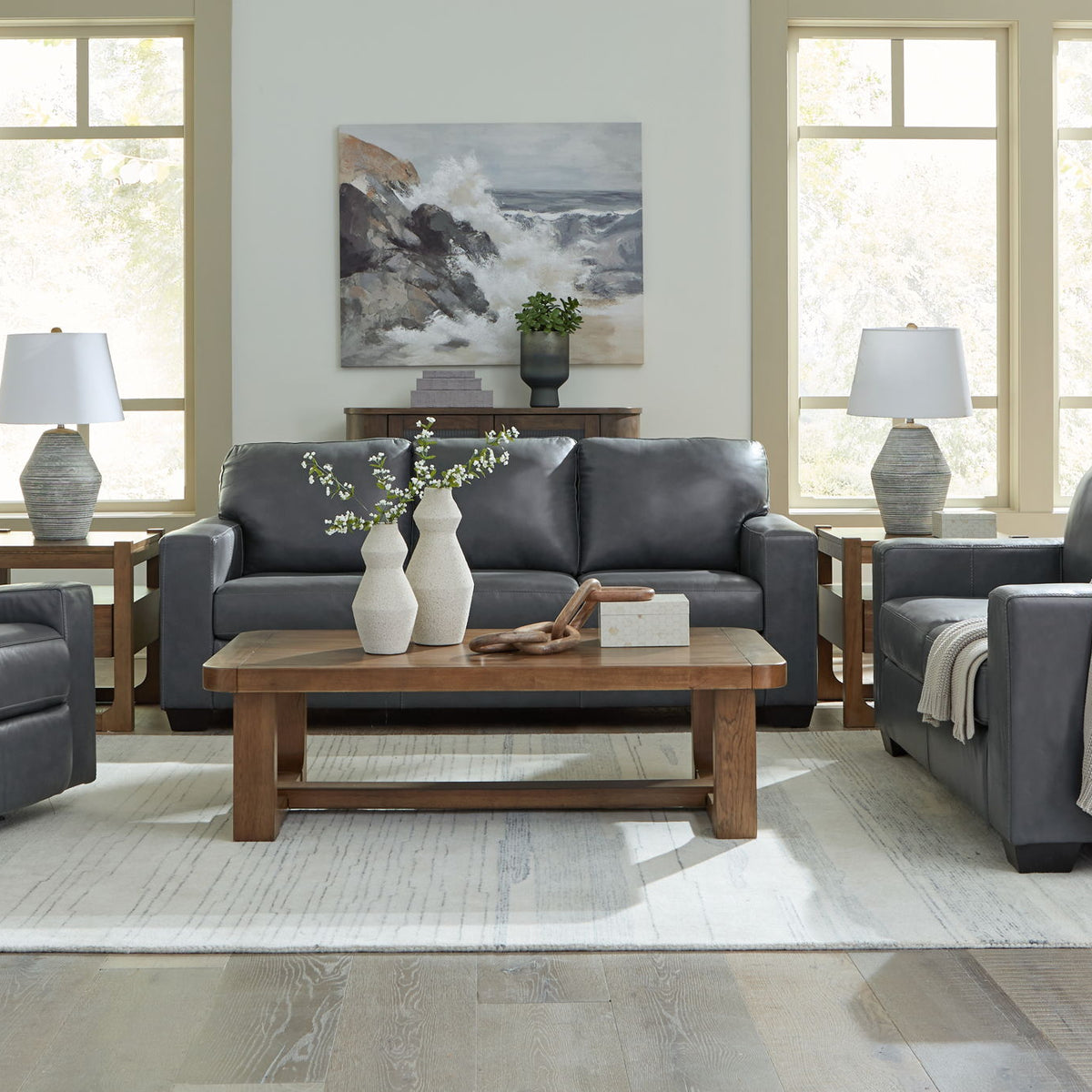 Gray upholstered loveseat with tufted cushions and matching sofa beside it
