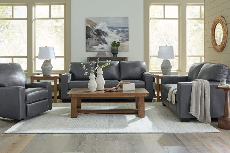 Gray upholstered loveseat with tufted cushions and matching sofa beside it