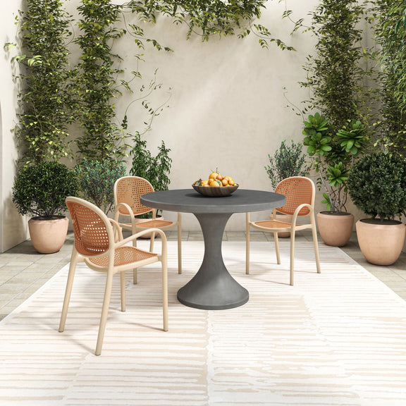 Outdoor dining table with round dark gray top and pedestal base, patio seating