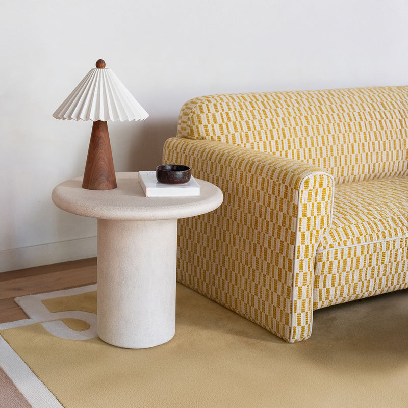 Cream outdoor side table, round tabletop on a smooth cylindrical pedestal base.