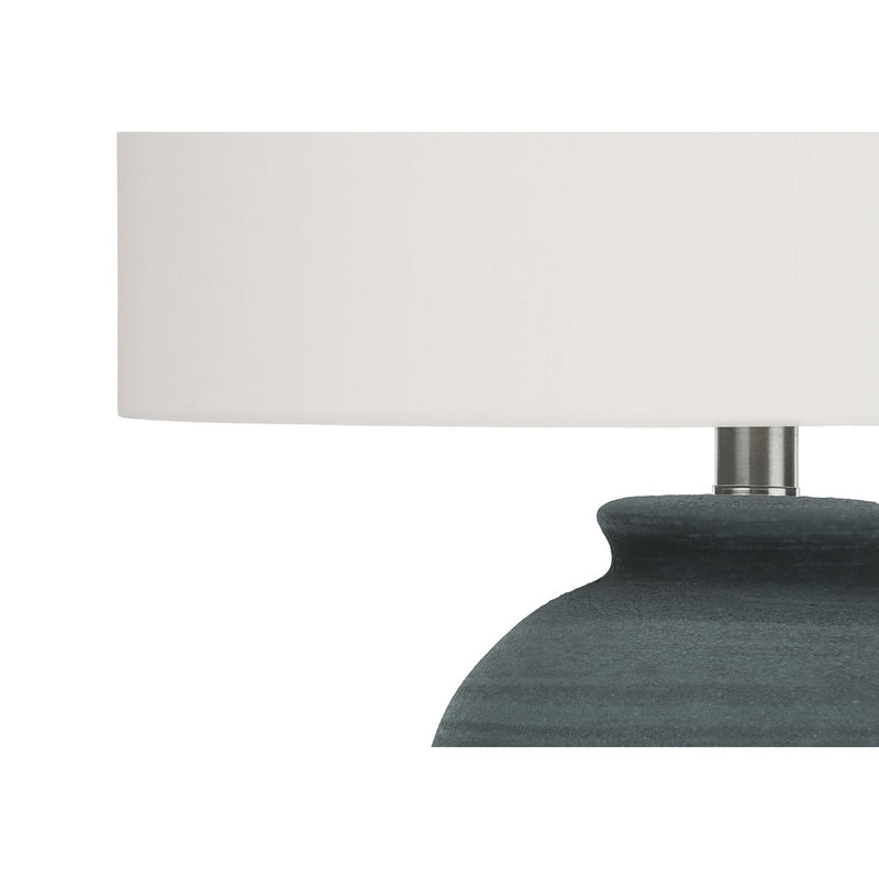 White drum shade and dark blue ceramic lamp base with metal neck