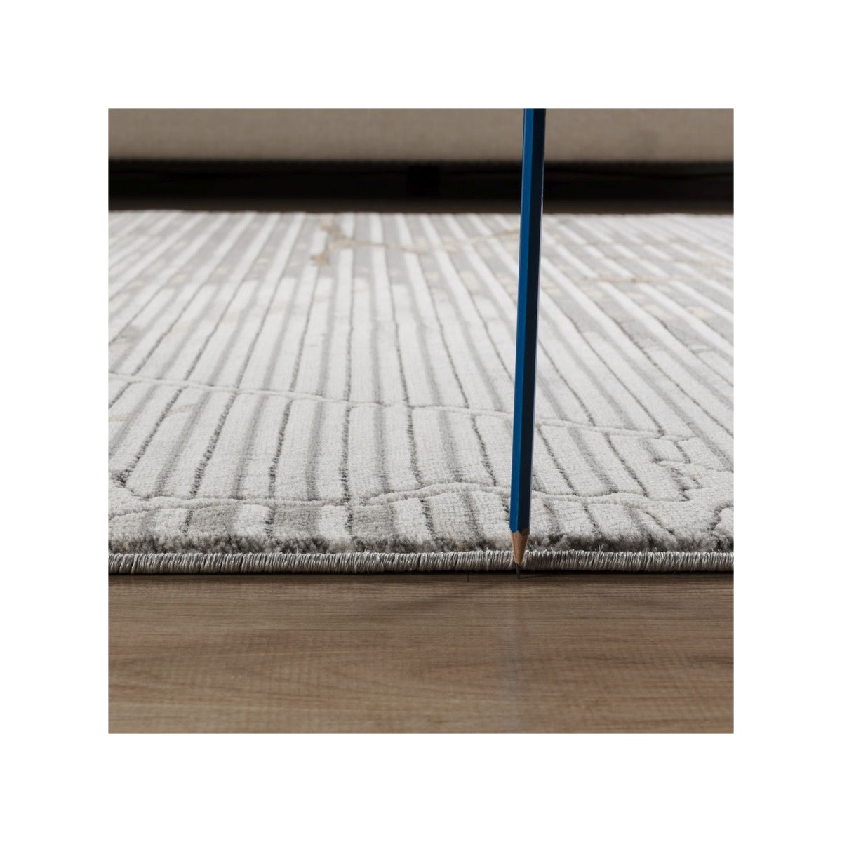 Gray geometric rug with gold-toned abstract pattern and stitched border