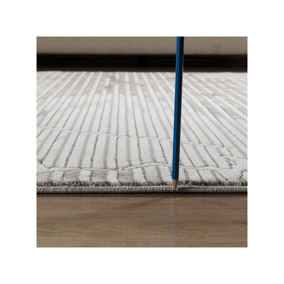 Gray geometric rug with gold-toned abstract pattern and stitched border