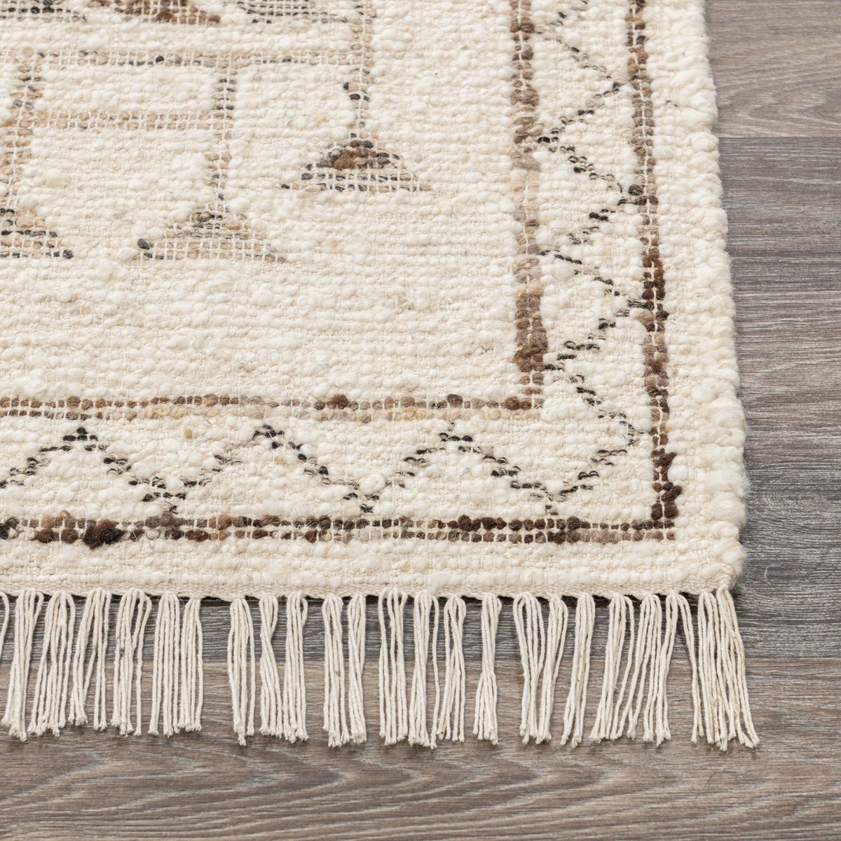 Ivory rug edge with short fringe and dark printed geometric border on flat weave