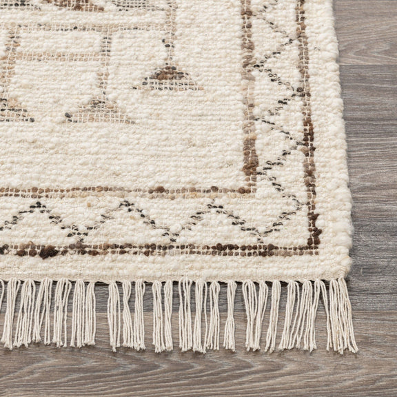 Ivory rug edge with short fringe and dark printed geometric border on flat weave