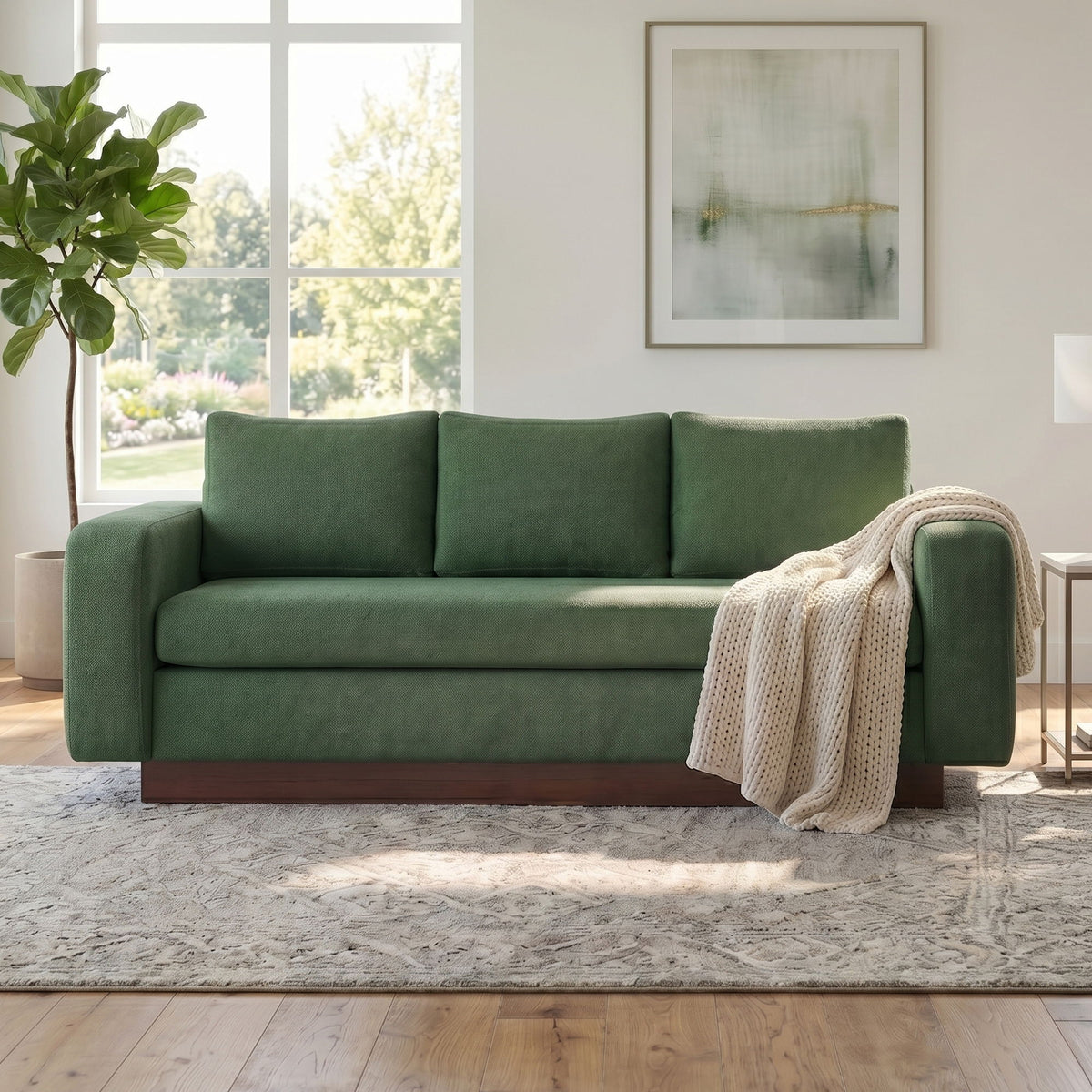 Dark green 3-seater sofa with three back cushions and beige throw on arm