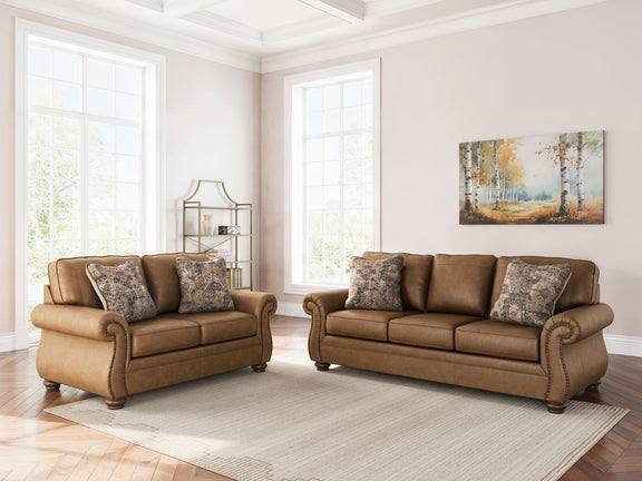 Living room set in dark brown with loveseat and sofa, patterned accent pillows on cushions