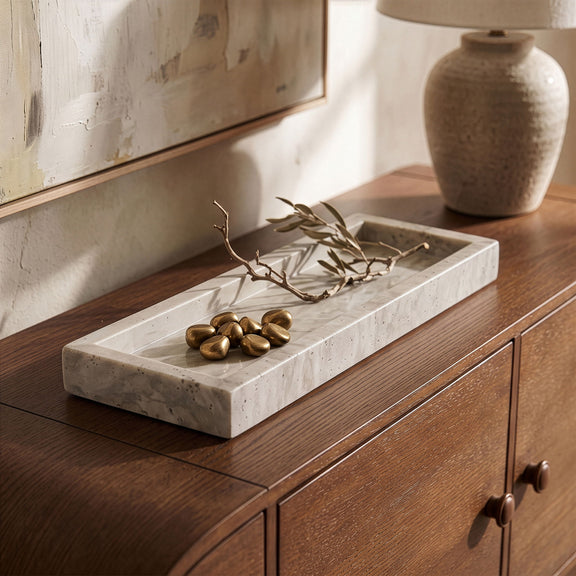 Beige travertine tray on dresser with small candles and flower stems on top
