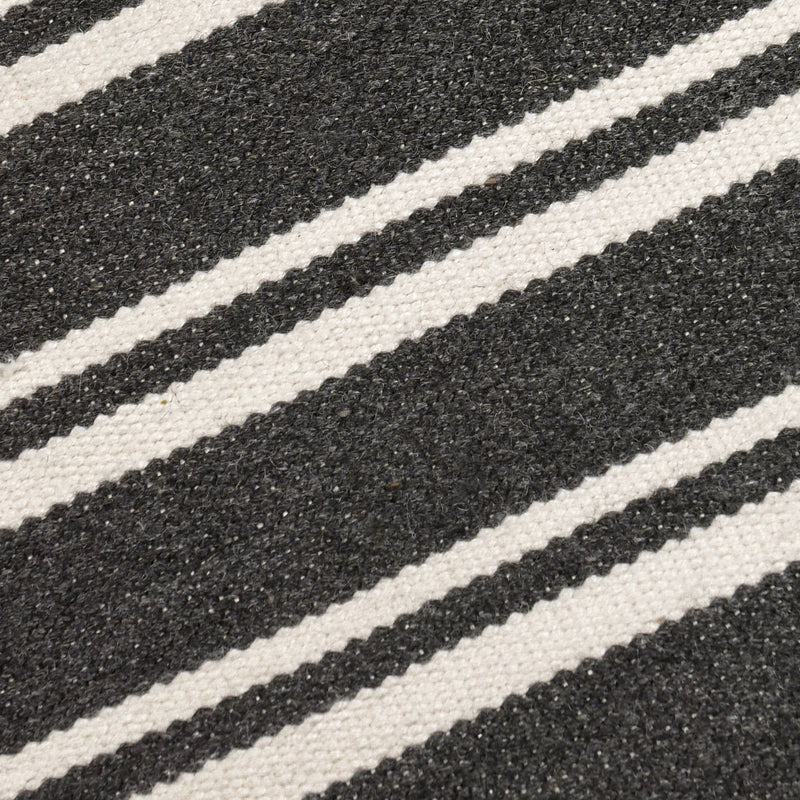 Close-up of charcoal rug with thick white stripe bands and visible woven fibers